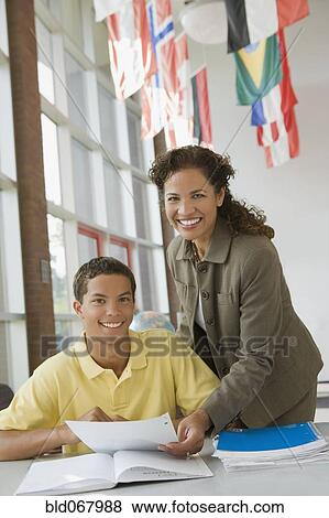 Teacher helping student with homework View Large Photo Image Stock Photo - Teacher helping student with homework. Fotosearch