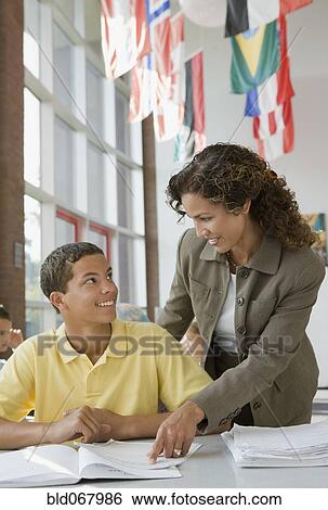 Stock Photograph - Teacher helping student with homework. Fotosearch