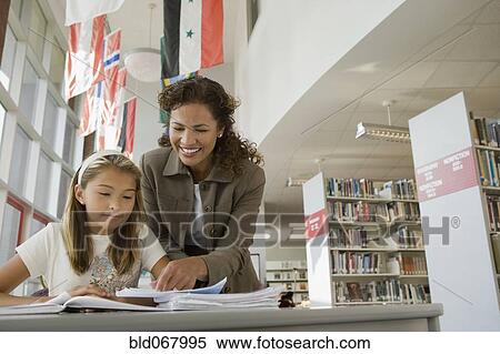 Stock Photography - Teacher helping student with homework. Fotosearch