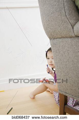 Toddler girl hiding behind chair View Large Photo Image Stock Photo - Toddler girl hiding behind chair. Fotosearch
