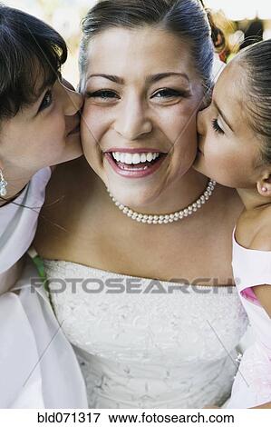 Stock Photo - Two girls kissing bride on cheeks. Fotosearch