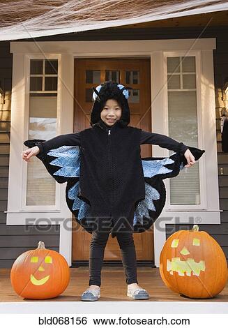 Stock Photograph - Young Chinese girl in butterfly costume with Halloween pumpkins. Fotosearch