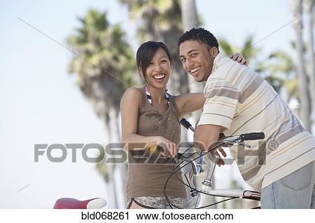 Young couple standing with bicycles View Large Photo Image Stock Image - Young couple standing with bicycles. Fotosearch