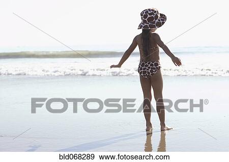 Young mixed race girl standing at beach View Large Photo Image Stock Photo - Young mixed race girl standing at beach. Fotosearch