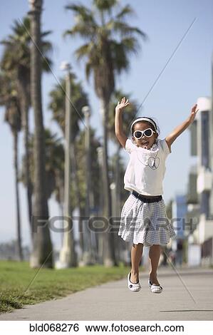 Young mixed race girl wearing sunglasses and jumping View Large Photo Image Stock Photograph - Young mixed race girl wearing sunglasses and jumping. Fotosearch
