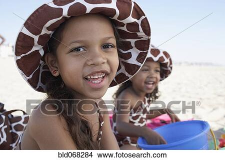 Picture - Young mixed race girls playing at beach. Fotosearch
