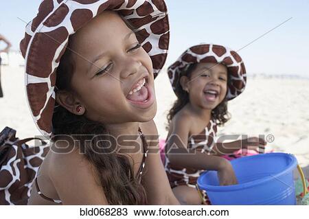 Stock Image - Young mixed race girls playing at beach. Fotosearch