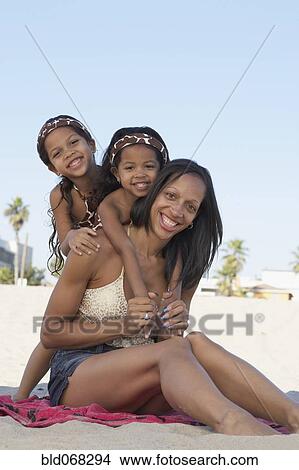 Picture - Young mixed race girls with mother at beach. Fotosearch
