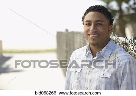 Stock Photograph - Young mixed race man standing outdoors. Fotosearch