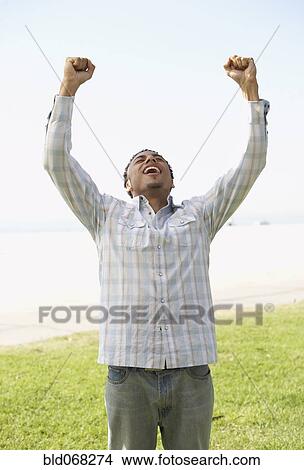 Young mixed race man with arms raised View Large Photo Image Picture - Young mixed race man with arms raised. Fotosearch