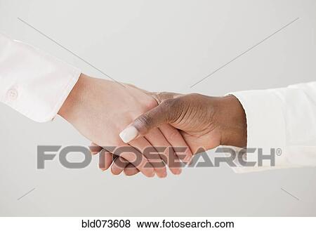 African and Caucasian woman shaking hands View Large Photo Image Stock Photo - African and Caucasian woman shaking hands. Fotosearch