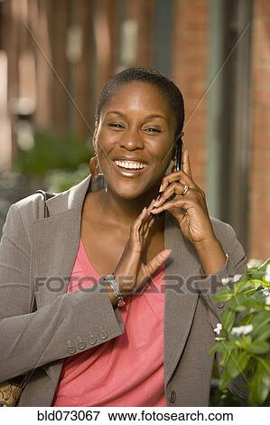 Stock Photo - African businesswoman talking on cell phone outdoors. Fotosearch