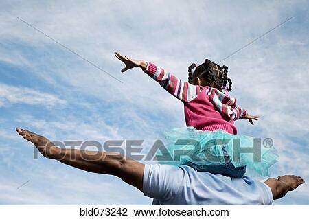 African father carrying daughter on shoulders View Large Photo Image Stock Image - African father carrying daughter on shoulders. Fotosearch