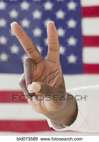 African woman making peace symbol near American flag View Large Photo Image Stock Photo - African woman making peace symbol near American flag. Fotosearch