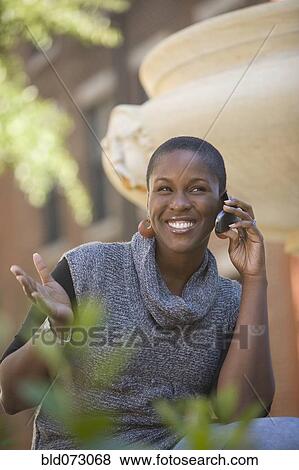 African woman talking on cell phone outdoors View Large Photo Image Stock Photo - African woman talking on cell phone outdoors. Fotosearch