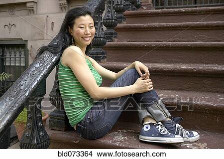 Asian woman sitting on front steps View Large Photo Image Picture - Asian woman sitting on front steps. Fotosearch