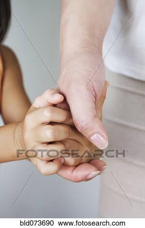 Stock Image - Chinese woman holding daughter’s hand. Fotosearch