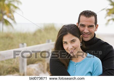 Hispanic couple hugging near ocean View Large Photo Image Stock Image - Hispanic couple hugging near ocean. Fotosearch