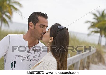 Hispanic couple kissing near ocean View Large Photo Image Stock Image - Hispanic couple kissing near ocean. Fotosearch