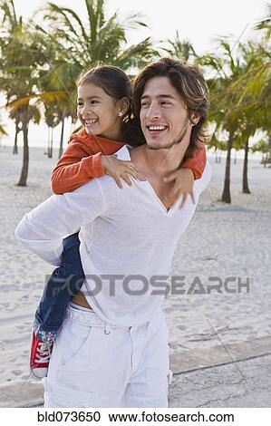 Hispanic father carrying daughter on back View Large Photo Image Stock Image - Hispanic father carrying daughter on back. Fotosearch