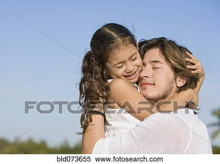 Stock Photography - Hispanic father hugging daughter. Fotosearch
