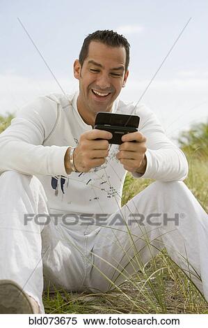 Hispanic man laughing at text message View Large Photo Image Stock Photography - Hispanic man laughing at text message. Fotosearch