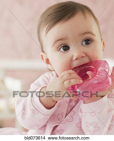 Mixed race baby girl chewing on plastic toy View Large Photo Image Picture - Mixed race baby girl chewing on plastic toy. Fotosearch