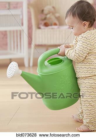 Mixed race baby girl holding watering can View Large Photo Image Stock Photo - Mixed race baby girl holding watering can. Fotosearch