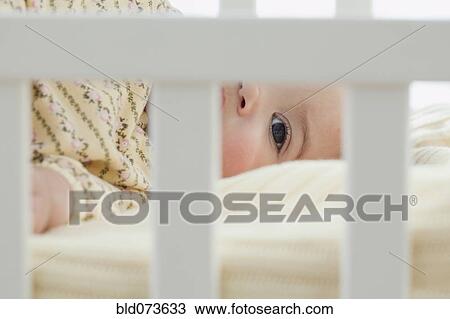 Mixed race baby girl laying in crib View Large Photo Image Stock Image - Mixed race baby girl laying in crib. Fotosearch
