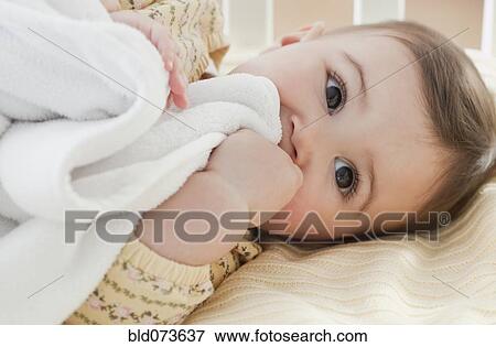 Stock Photo - Mixed race baby girl laying in crib. Fotosearch