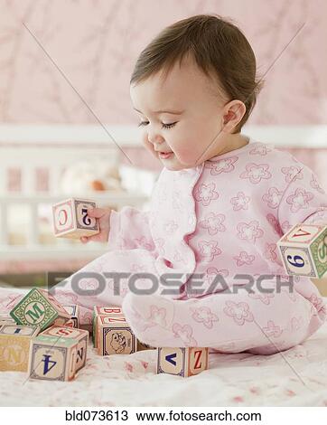 Stock Image - Mixed race baby girl playing with alphabet blocks. Fotosearch