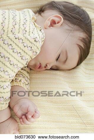 Stock Image - Mixed race baby girl sleeping. Fotosearch