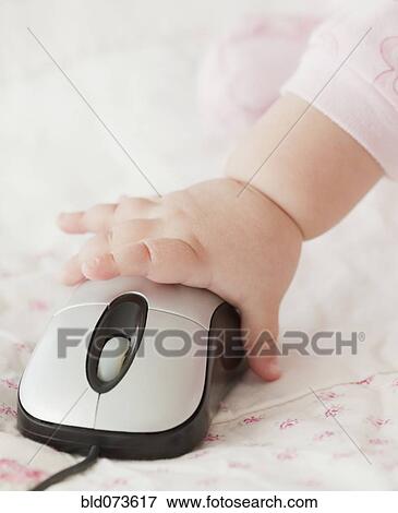 Stock Photo - Mixed race baby girl using computer mouse. Fotosearch