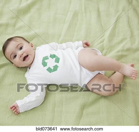 Stock Image - Mixed race baby girl with recycling symbol on shirt. Fotosearch