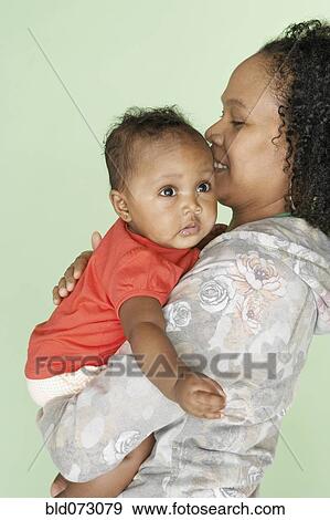Mixed race mother holding baby daughter View Large Photo Image Stock Photo - Mixed race mother holding baby daughter. Fotosearch