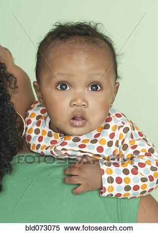 Stock Photography - Mixed race mother holding baby daughter. Fotosearch