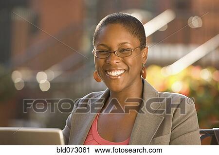 Smiling African businesswoman working outdoors View Large Photo Image Stock Image - Smiling African businesswoman working outdoors. Fotosearch