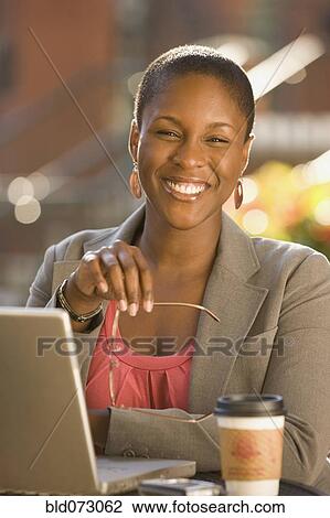 Smiling African businesswoman working outdoors View Large Photo Image Stock Image - Smiling African businesswoman working outdoors. Fotosearch
