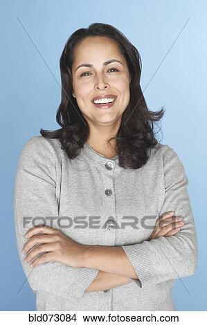 Picture - Smiling Hispanic woman with arms crossed. Fotosearch