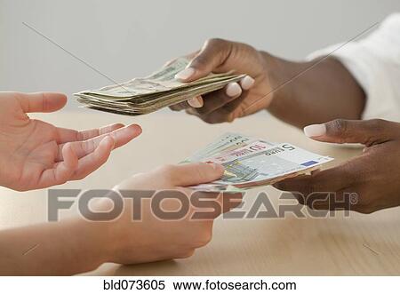 Stock Image - Woman exchanging Euro notes for US currency. Fotosearch - Search Stock Photos, Mural Pictures, Photographs, and Photo Clipart