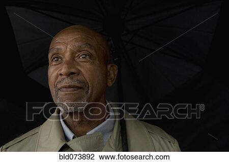 African businessman holding umbrella View Large Photo Image Stock Image - African businessman holding umbrella. Fotosearch