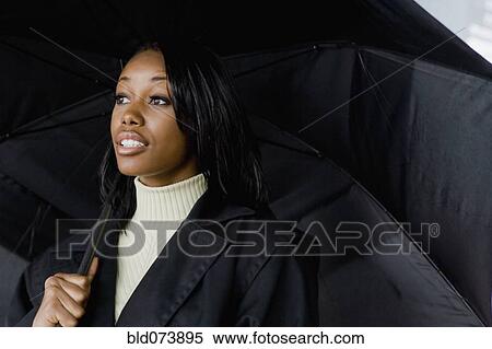 Stock Photography - African businesswoman holding umbrella. Fotosearch