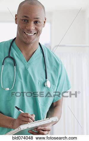 African doctor writing in medical chart View Large Photo Image Stock Photo - African doctor writing in medical chart. Fotosearch