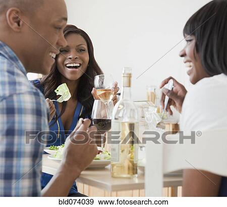 Stock Photo - African friends enjoying dinner party. Fotosearch