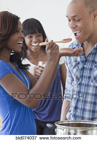 Stock Photo - African man tasting tomato sauce. Fotosearch