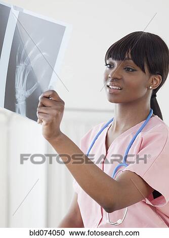 African nurse looking at hand x-ray View Large Photo Image Stock Image - African nurse looking at hand x-ray. Fotosearch