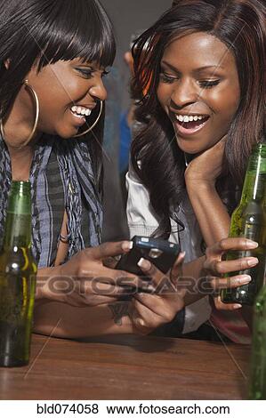 African woman drinking beer and text messaging View Large Photo Image Stock Photo - African woman drinking beer and text messaging. Fotosearch