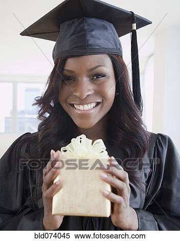 African woman in graduation cap and gown holding gift View Large Photo Image Stock Photography - African woman in graduation cap and gown holding gift. Fotosearch