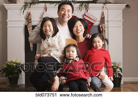 Stock Image - Asian family posing for Christmas photograph. Fotosearch