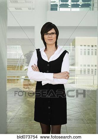 Picture - Hispanic businesswoman standing in office lobby. Fotosearch